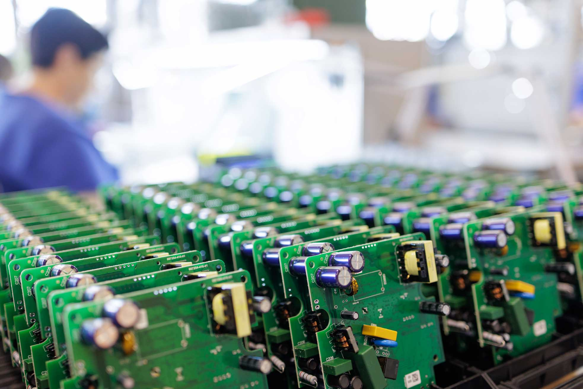 Rows of assembled circuit boards on a manufacturing line after DFM-aligned fab and assembly