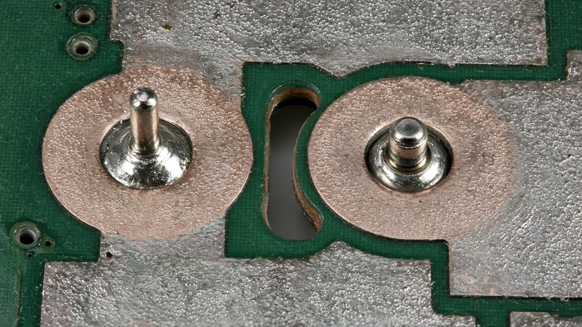 Screw terminal blocks soldered to wide copper pours on a power PCB, viewed from above